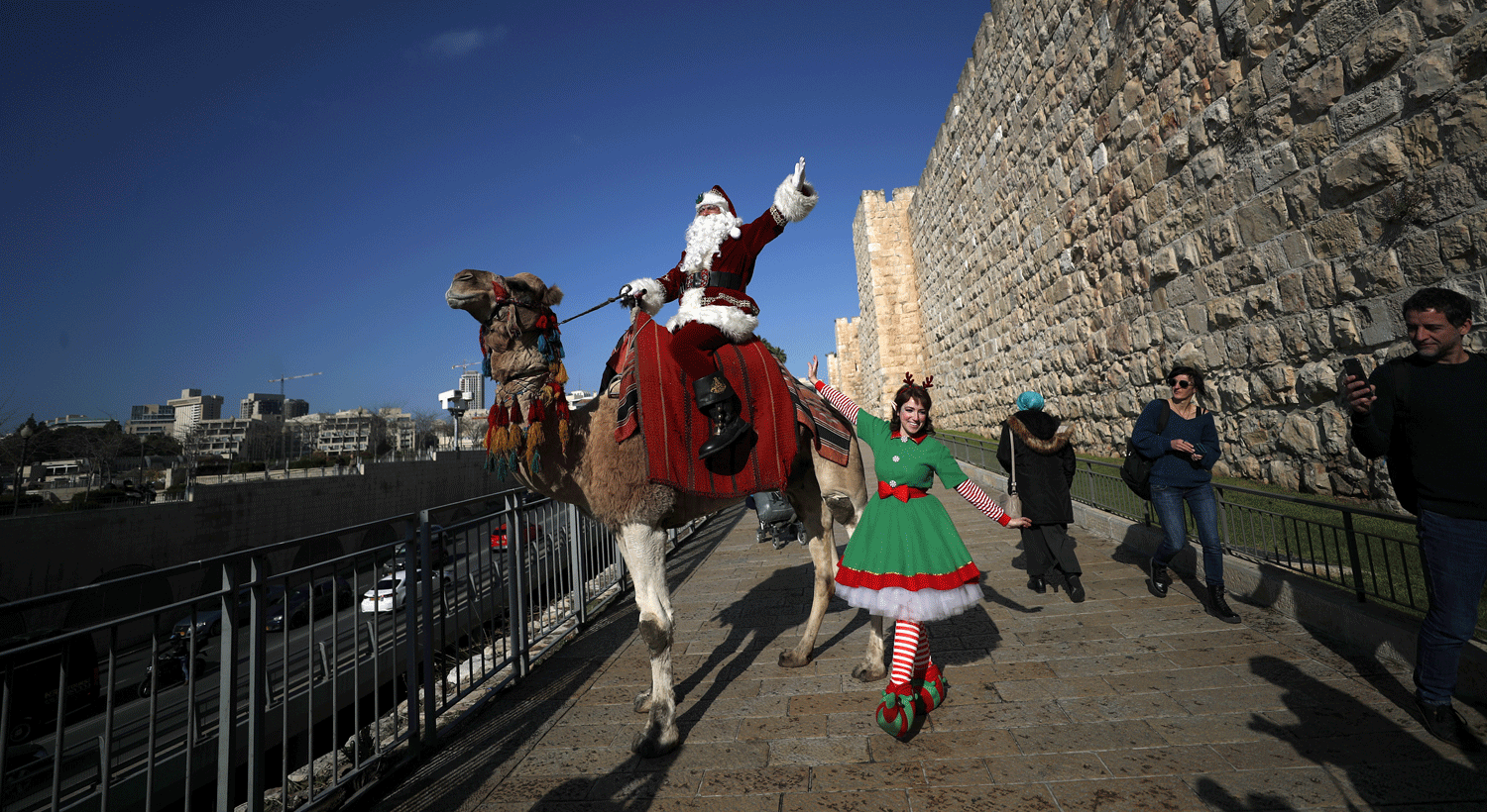  Diplomata palestiniano Issa Kassissieh cumprimenta as pessoas enquanto monta um camelo na cidade velha de Jerusal&eacute;m. Cr&eacute;ditos: EPA/ATEF SAFADI 
