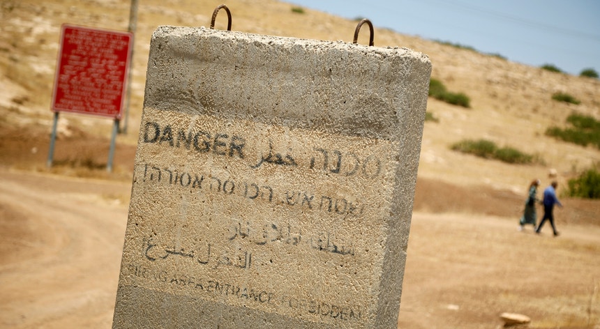 No Vale do Jordão, na Cisjordânia ocupada, um separador de betão adverte para o  perigo de circular em zona de disparos frequentes
