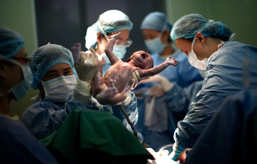 Um médico segura um recém-nascino num hospital em Xangai
