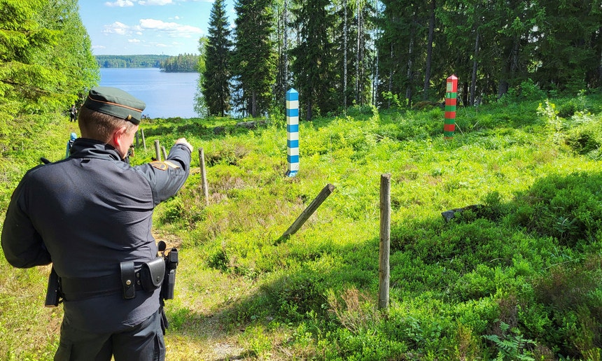 Guardas de fronteira finlandeses patrulham a fronteira entre a Finlândia e a Rússia, marcada por uma estreita clareira na floresta perto da aldeia de Hoilola, no leste da Finlândia
