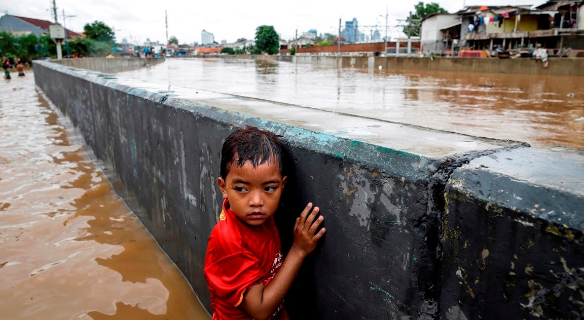  Indon&eacute;sia, Jacarta. Menino aguarda ajuda numa rua inundada | Mast Irham - Epa   