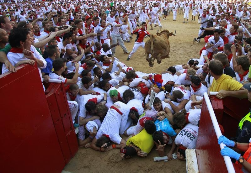  No primeiro dia das largadas, 7 de Julho, um touro salta para a arena e para uma corrida de 4 minutos com alguns feridos ligeiros. Foto: Joseba Etxaburu / Reuters 