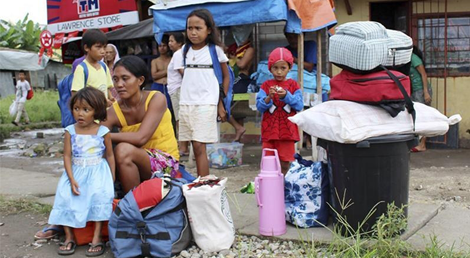 Filipinos de Tacloban esperam transporte do governo para centro de ref&uacute;gio do tuf&atilde;o Hagupit (Foto: Reuters)