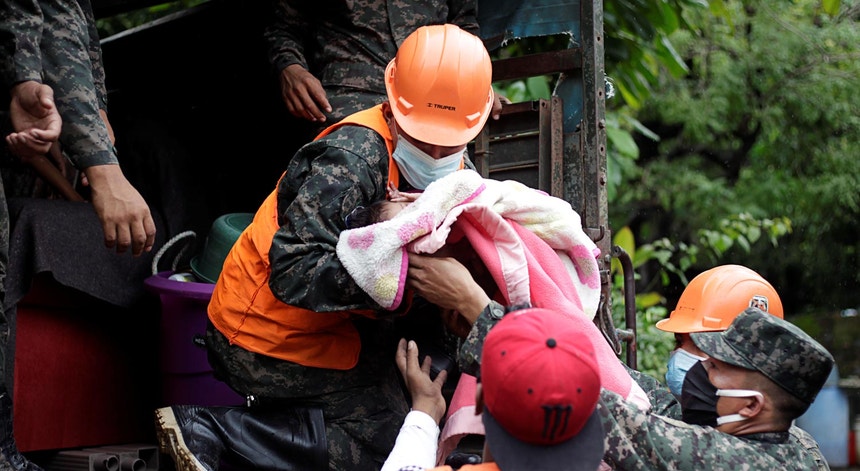 Um soldado hondurenho segura um bebé durante as evacuações de vilas e aldeias devido ao furacão Iota, 15 dias após o Eta
