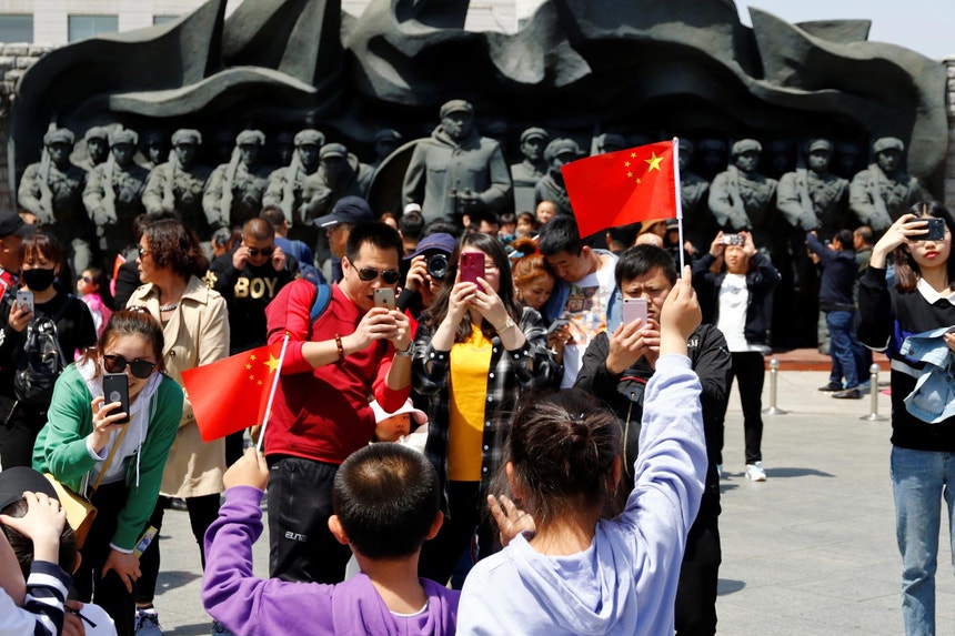 Imagem relacionada com a notícia: Sessão de fotos junto ao recém inaugurado monumento aos soldados chineses mortos na Guerra da Coreia, em Dandong, perto do rio Yalu
