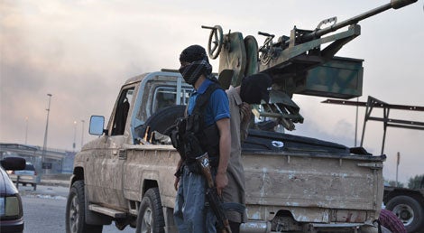 Militante do EIIL (Estado Isl&acirc;mico do Iraque e do Levante) num posto de controlo &agrave;s portas de Mossul (Foto: Reuters)