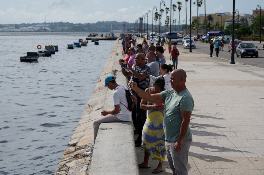 Cubanos, no porto de Havana, em junho a verem o submarino e a fragata russa.
