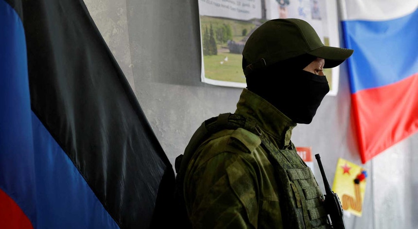Um militar vigia uma mesa de voto na autoproclamada República Popular de Donetsk. 
