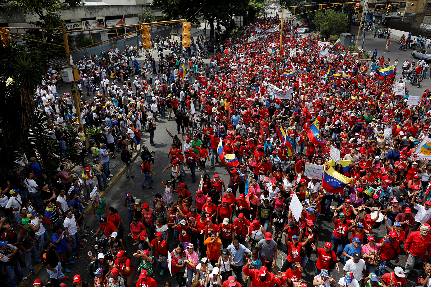  Os apoiantes (de vermelho) do Presidente da venezuelano Nicolas Maduro marcham frente aos apoiantes da oposi&ccedil;&atilde;o / Carlos Garcia Rawlins - Reuters 