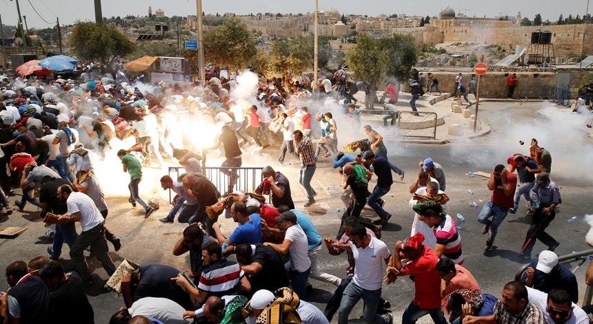Palestinianos fogem de uma granada de gás lacrimogéneo lançada pela polícia israelita numa das ruas da cidade velha de Jerusalém, durante protestos contra a instalação de detetores de metais à entrada do Monte do Templo
