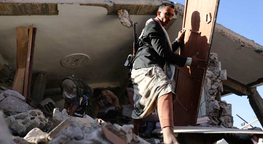 Um prédio em Sanaa ficou reduzido a escombros após um bombardeamento aéreo saudita a 18 de janeiro de 2022

