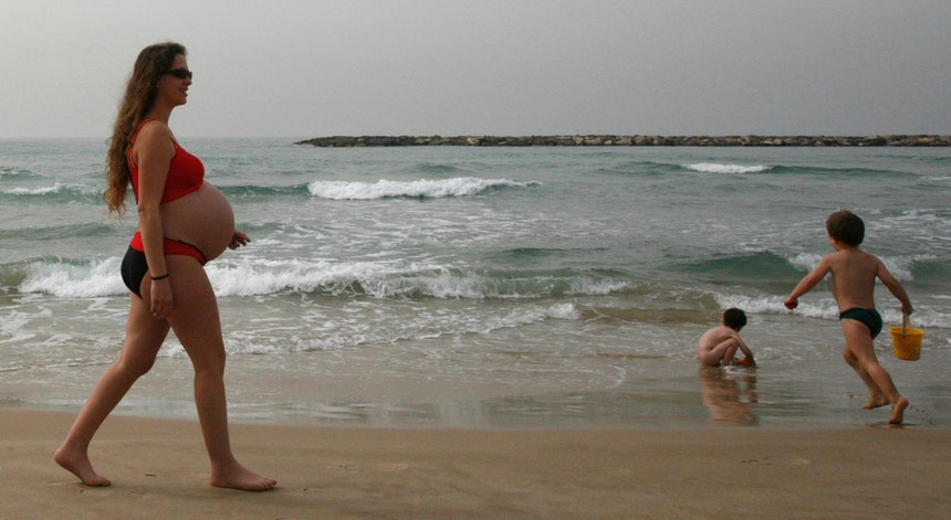 Uma mulher grávida passeia à beira-mar em Televive, durante uma onda de calor em fevereiro de 2010
