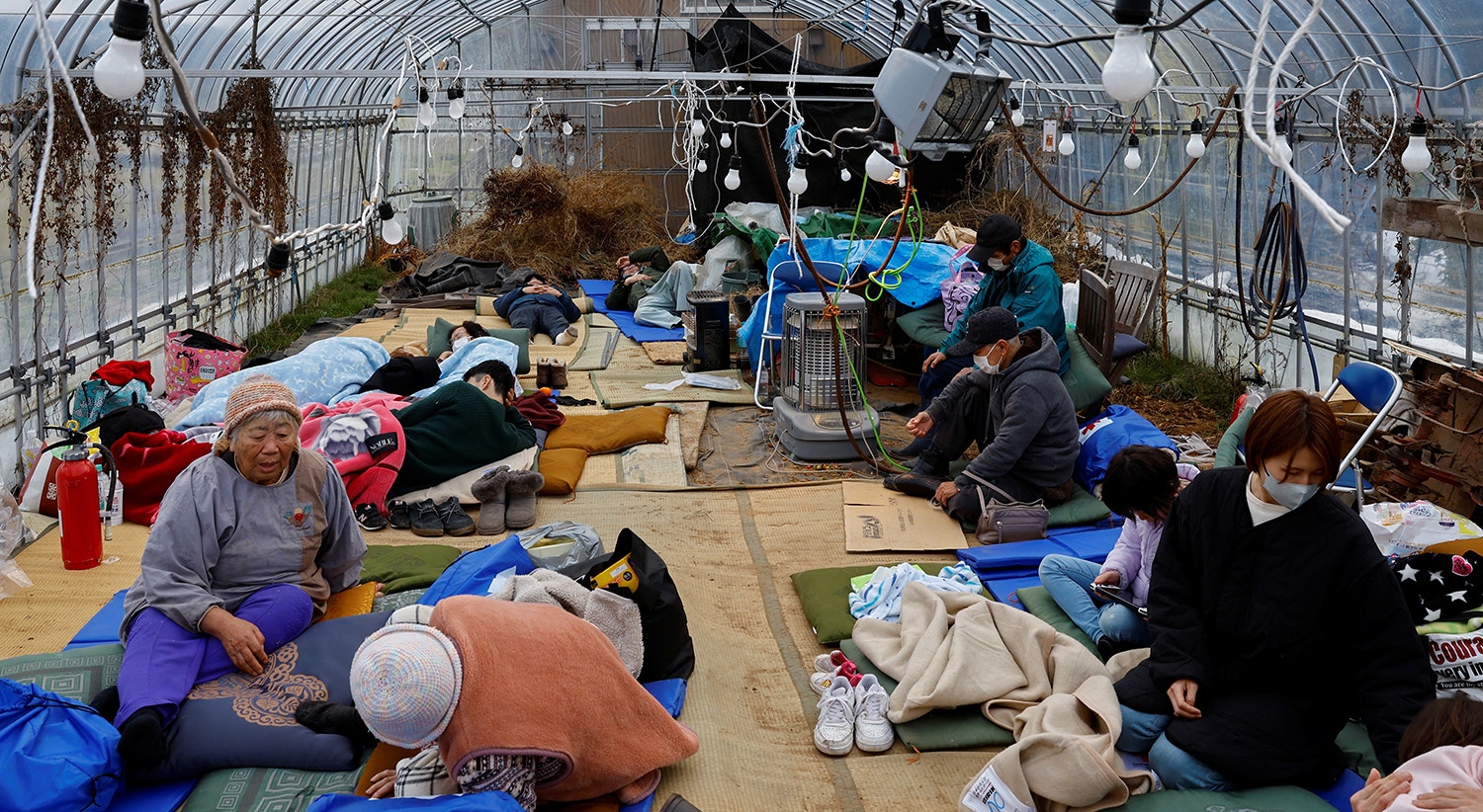  Pessoas descansam numa estufa convertida em centro de abrigo, em Wajima, 2 de janeiro | Foto: Kim Kyung-Hoon - Reuters 