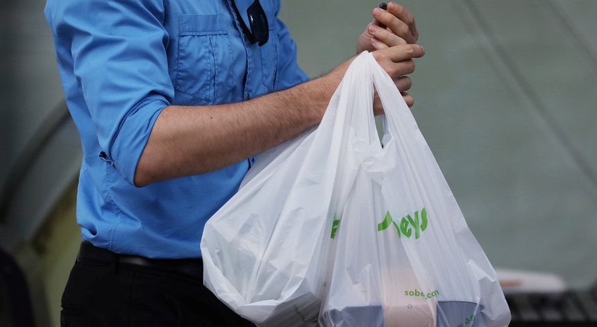 No Canadá, uma pessoa carrega as compras em sacos de plástico
