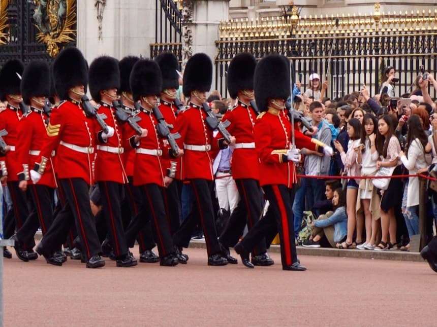 Um guarda com uma túnica vermelha e chapéu de pele de urso deve estar sempre em alerta para proteger a Rainha, por isso a mudança da guarda é uma tradição vital
