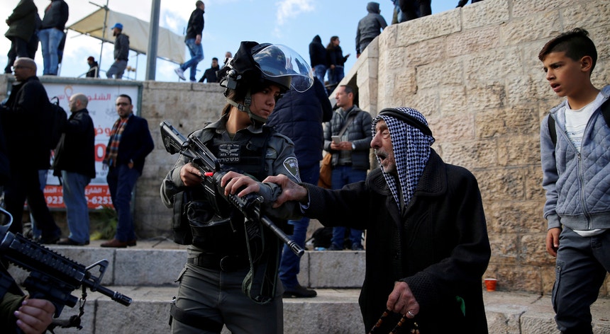 Um palestiniano discute com uma agente da polícia fronteiriça de Israel durante protestos na Cidade Velha de Jerusalém
