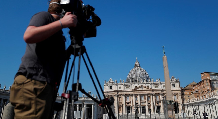 Um reporter capta imagens da Basílica de São Pedro no Vaticano a 12 de abril de 2020, durante a pandemia de Covid-19
