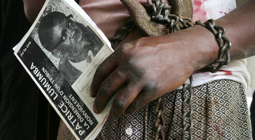 Um congolês segura um livro com uma fotografia de Patrice Lumumba enquanto participa num protesto em Bruxelas
