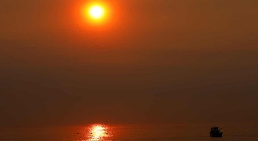 O sol visto no mar através do fumo causado por um dos devastadores incêndios registados na Califórnia em 2017
