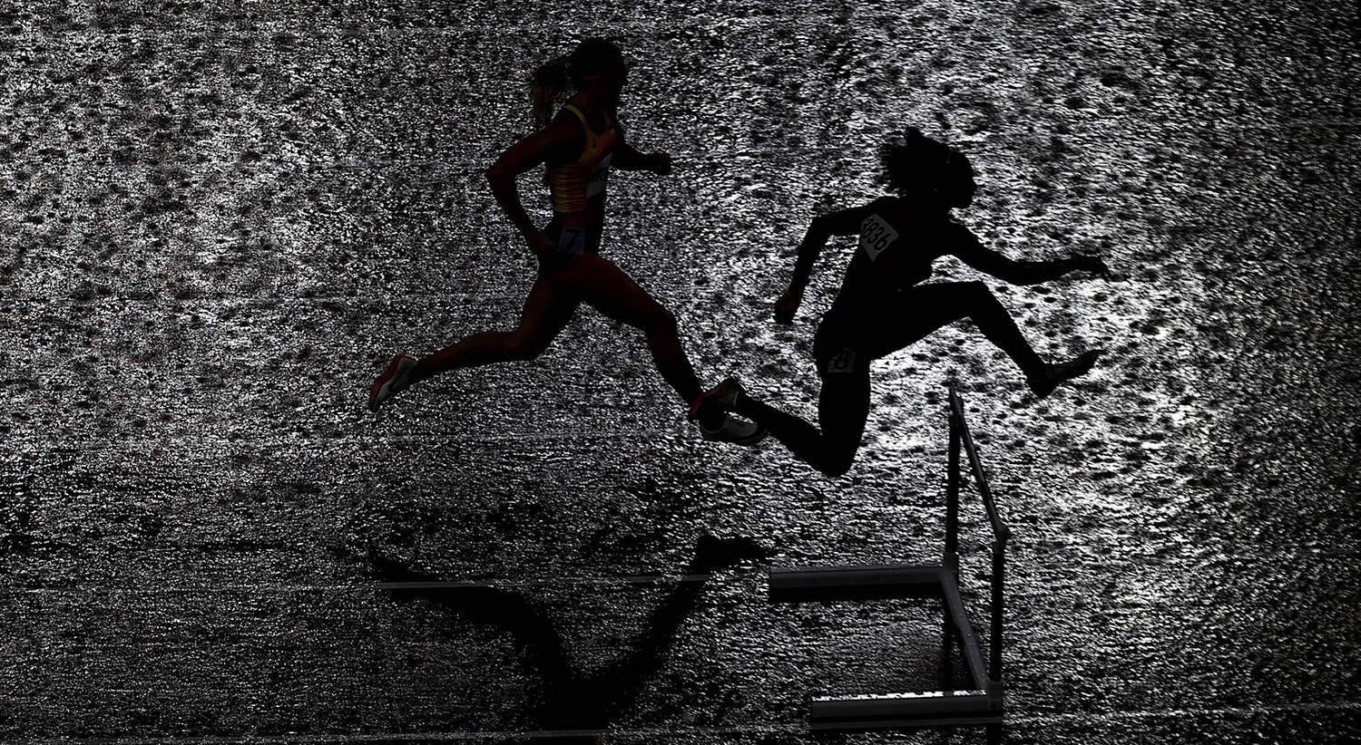  A chuva intensa durante a prova de 400m de barreiras feminina. | Foto: Hannah Mckay - Reuters 
