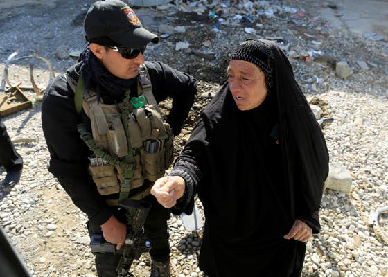 Num posto de controlo em Kokjali, a leste de Mossul, um efetivo das forças especiais do Iraque ouve uma mulher que escapou da cidade (foto: Zohra Bensemra - Reuters)