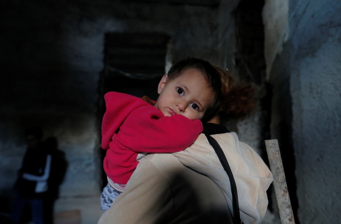  M&atilde;e e filho a recolherem-se em abrigo | Reuters 