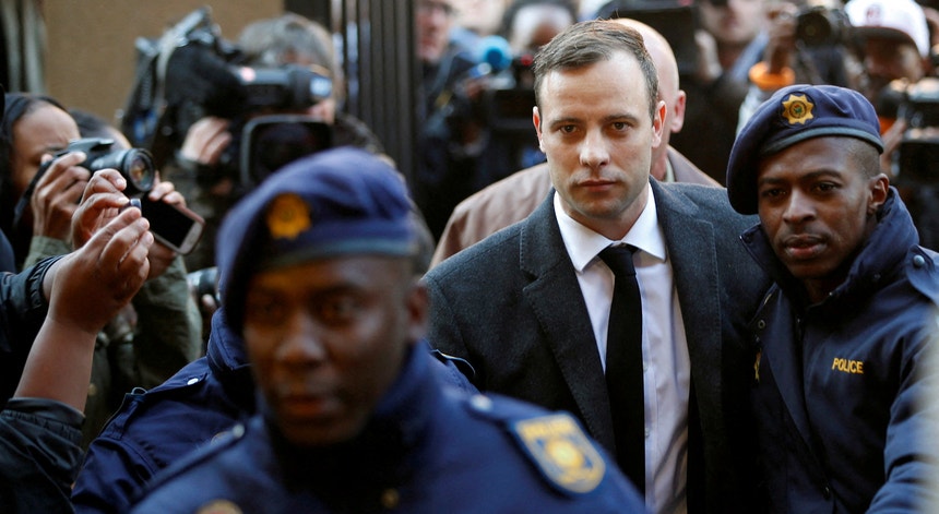 Imagem relacionada com a notícia: Oscar Pistorius é escoltado por polícias junto ao Tribunal Superior de North Gauteng em Pretória, África do Sul, a 6 de julho de 2016, para ouvir a sentença.
