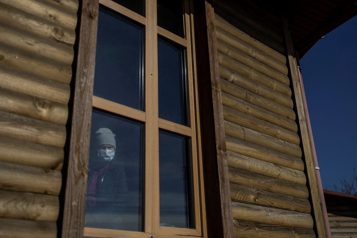 Uma ucraniana espreita pela janela de uma igreja em Mariupol, em mar&ccedil;o de 2022 Foto - Reuters