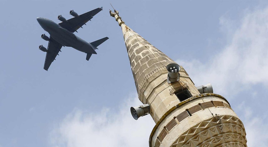 Um avião de carga da Força Aérea dos EUA Boeing C-17A Globemaster III sobrevoa um minarete na base aérea turca de Inçirlik, em março de 2016
