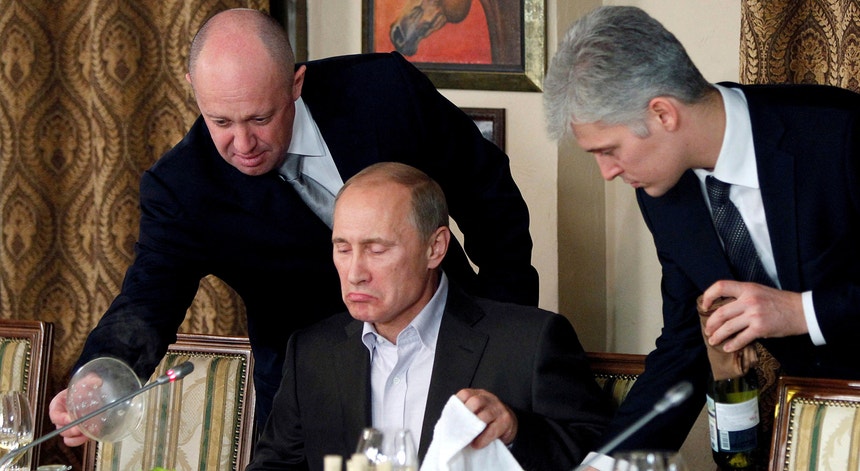 Nesta fotografia captada em 2011, Evgeny Prigozhin, à esquerda, serve Vladimir Putin durante um jantar nos arredores de Moscovo
