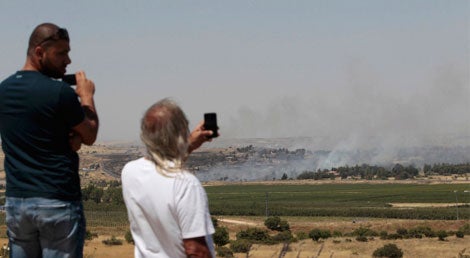 Residentes assistem aos combates entre rebeldes e ex&eacute;rcito s&iacute;rios pelo posto fronteiri&ccedil;o dos monte Gol&atilde; no dia 6 de maio de 2013