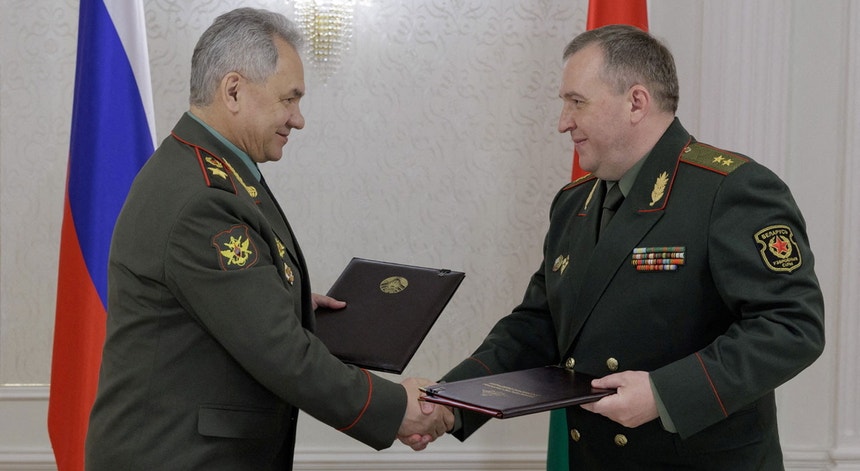 Sergei Shoigu, ministro da Defesa da Rússia, aperta a mão do seu homólogo bielorrusso, Victor Khrenin, na troca dos acordos nucleares assinados em Minsk, a 25 de maio de 2023
