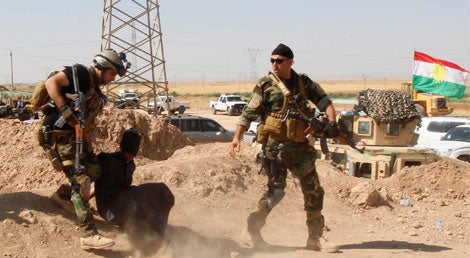 Tropas curdas dominam um alegado militante do Estado Isl&acirc;mico. Muitas vezes os suspeitos de pertencerem ao grupo radical s&atilde;o sumariamente executados quando s&atilde;o capturados pelas popula&ccedil;&otilde;es locais que se op&otilde;em ao dom&iacute;nio do EI (Foto: Reuters)