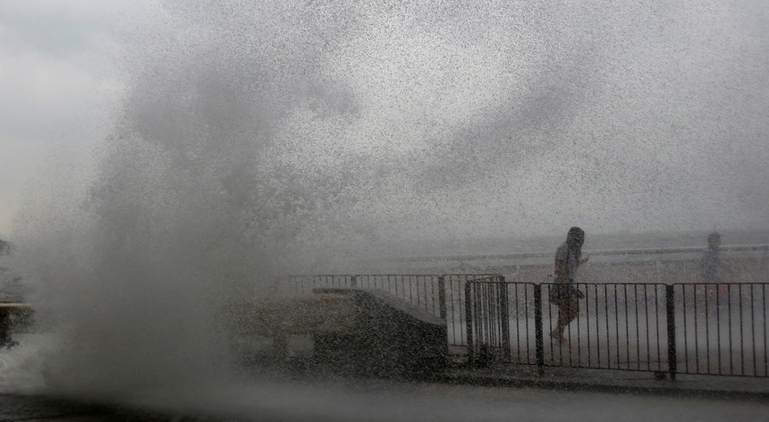 Uma pessoa foge das ondas provocadas pelo tufão Haima à chegada a Hong Kong
