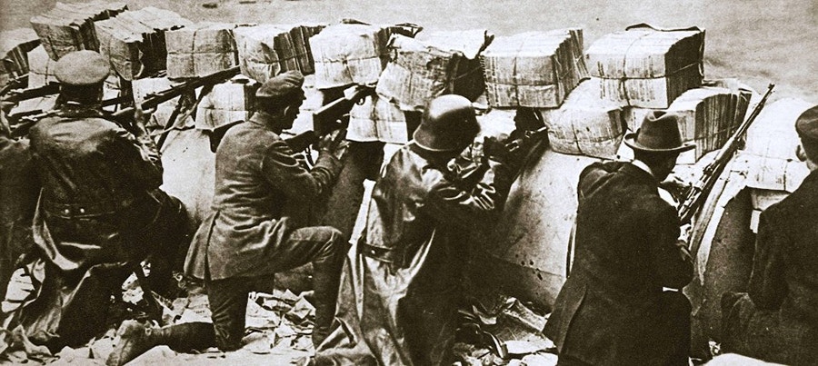  Espartaquistas, combatendo numa barricada com jornais e rolos de papel, em 11 de Janeiro de 1919, em Berlim. 