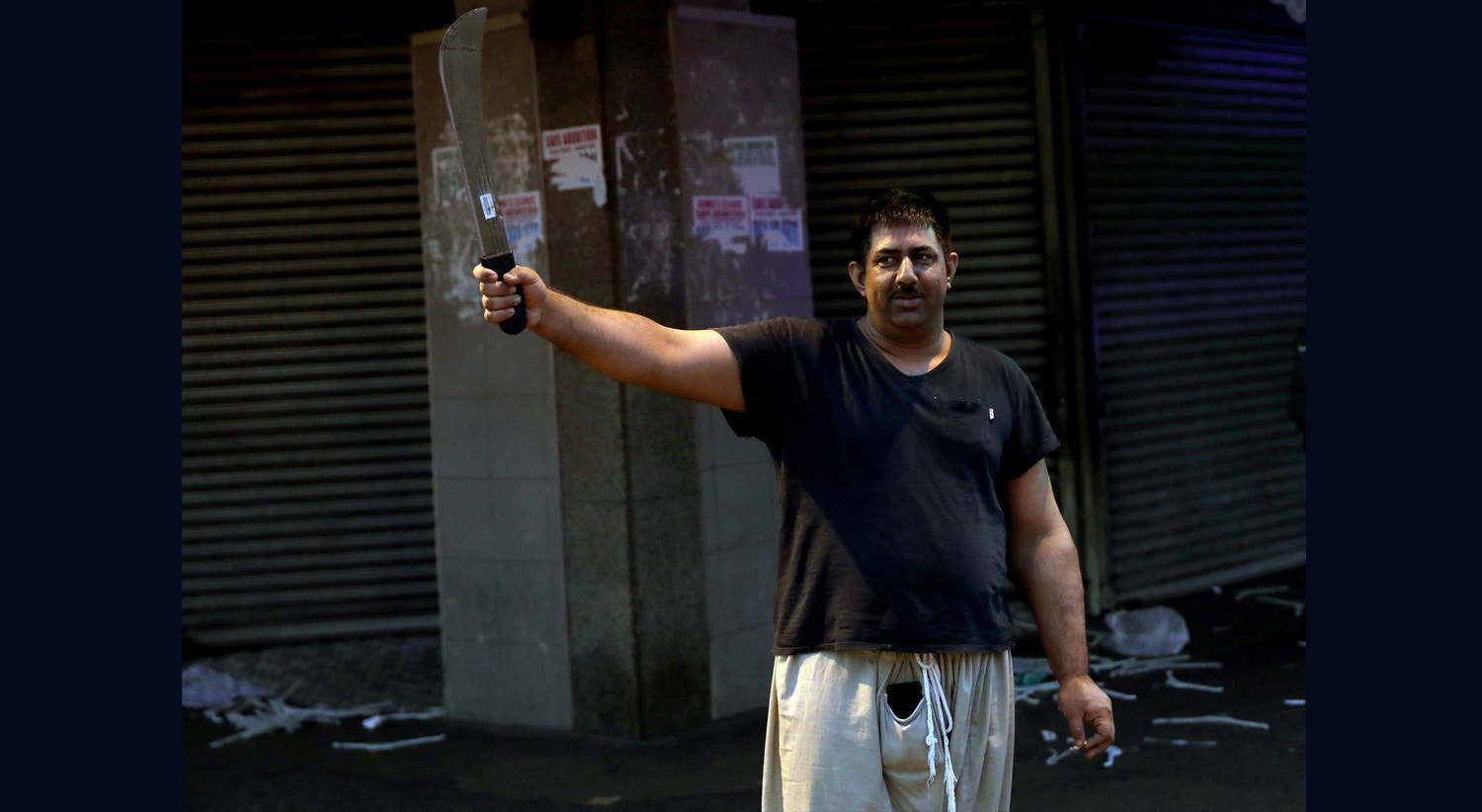  O propriet&aacute;rio de uma loja segura um manchete depois de passar a noite acordado para proteger o seu neg&oacute;cio em Durban | Foto:EPA 