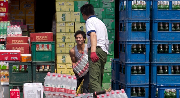 Trabalhadores descarregam mercadorias num mercado abastecedor dos arredores de Pequim
