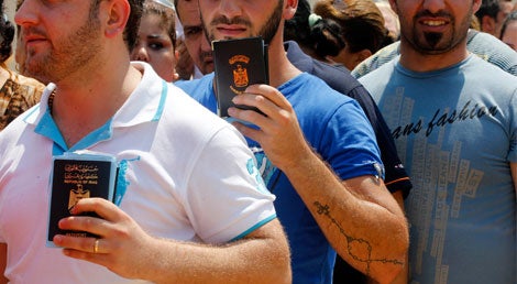Crist&atilde;os iraquianos refugiados em Beirute,L&iacute;bano, mostram  o seu passaporte para conseguir aux&iacute;lio humanit&aacute;rio a 13 de agosto 2014 (Foto: Reuters)