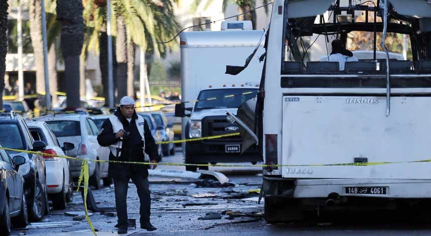 Um técnico forense da polícia tunisina investiga o autocarro atingido pelo ataque de terça-feira
