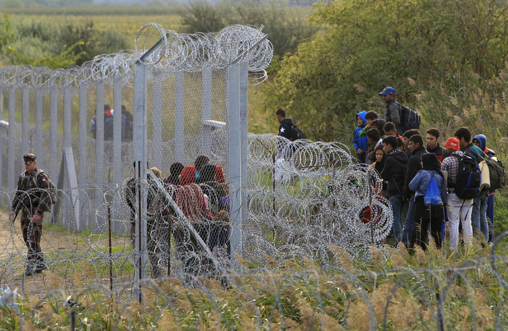 Refugiados passaram a noite ao relento do lado s&eacute;rvio frente &agrave; barreira de arame farpado erguida pela Hungria na fronteira com a S&eacute;rvia Foto: Reuters