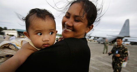 A alegria e o al&iacute;vio de uma m&atilde;e ao chegar a Manila, vinda de Tacloban, Filipinas; a popula&ccedil;&atilde;o anseia fugir da devasta&ccedil;&atilde;o causada pelo Haiyan (Reuters)