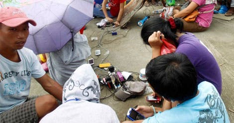 Mesmo entre os destroços, o carregamento de telemoveis junto a qualquer gerador é uma prioridade para dar e receber noticias de familiares e amigos após o tufão Haiyan (Reuters) Mesmo entre os destroços, o carregamento de telemoveis junto a qualquer gerador é uma prioridade para dar e receber noticias de familiares e amigos após o tufão Haiyan (Reuters)