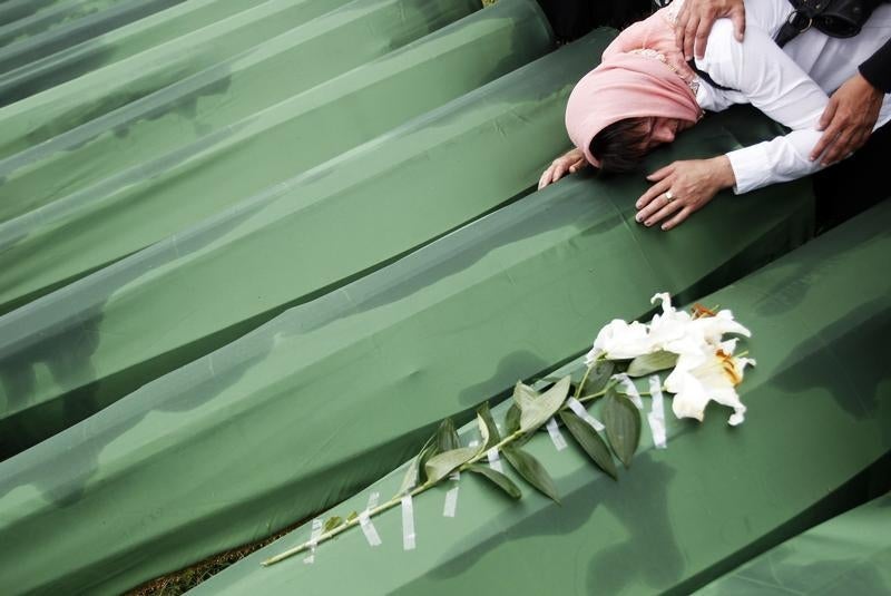 Uma mulher chora em julho de 2013 sobre o caix&atilde;o onde jazem os restos mortais de um seu familiar, morto do massacre de Srebenica Foto: Reuters