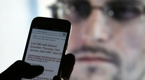 Algu&eacute;m acompanha no telem&oacute;vel as respostas via Twitter de Snowden em janeiro de 2014. Foto: Reuters