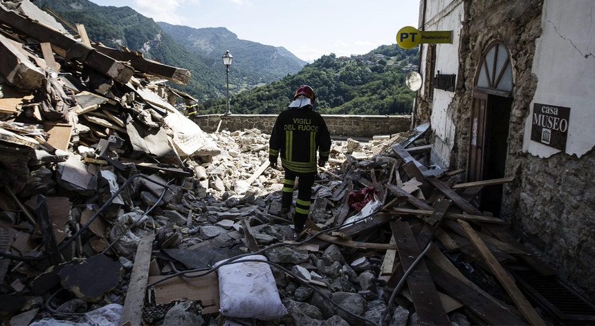 Um bombeiro atravessa uma pilha de escombros em Arquata, no centro de Itália
