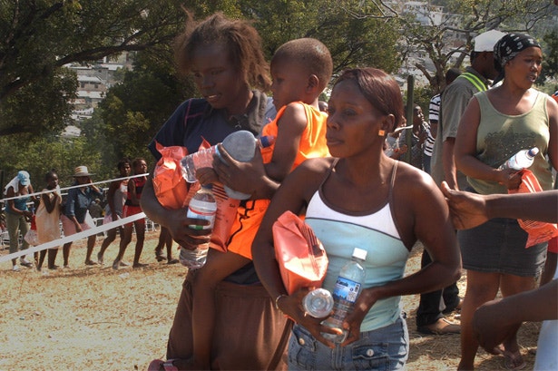  Um grupo de m&atilde;es haitianas recebe &aacute;gua alimentos distribu&iacute;dos por soldados dos Estados Unidos 