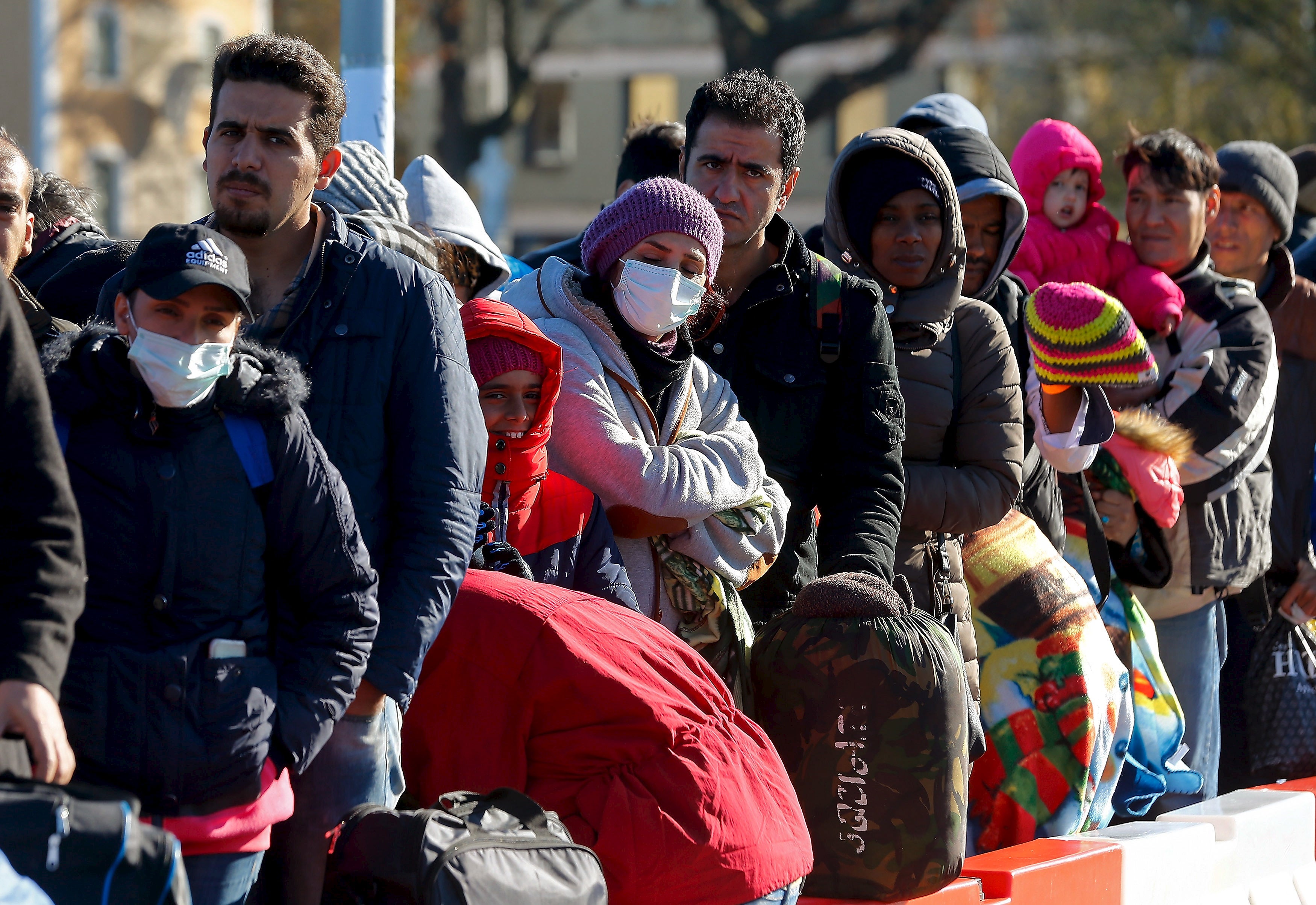 Migrantes fazem fila dia 1 de novembro numa ponte sobre um rio que divide a &Aacute;ustria e a Alemanha Foto: Reuters