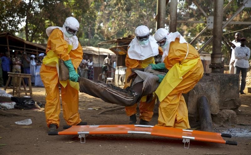 Elementos da Cruz Vermelha transportam um homem suspeito de estar infetado com ébola, em janeiro de 2015, na Guiné-Conacri.
