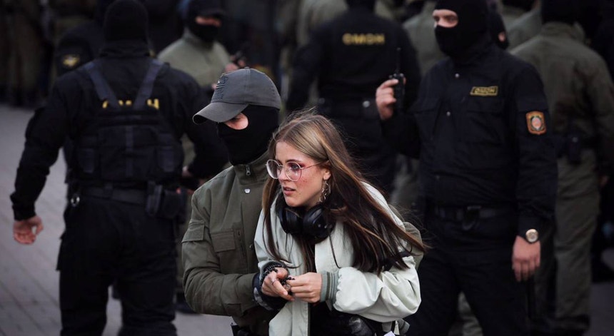 Uma mulher é detida por um agente da polícia bielorrusso durante os protestos de sábado
