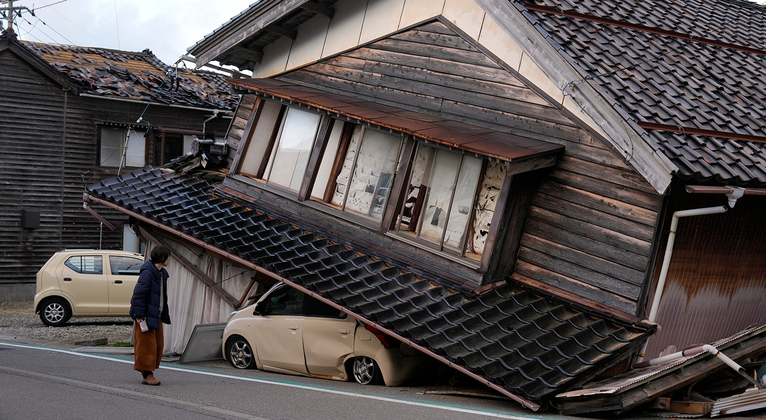  Kanae Yamazaki observa a casa onde cresceu na cidade de Togi, Pen&iacute;nsula de Noto (2 de janeiro) . Kanae Yamazaki conta que sua m&atilde;e estava na casa durante o terremoto, mas milagrosamente sobreviveu ao desabamento do edif&iacute;cio. | Foto: Franck Robichon - EPA 